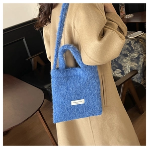 Detailed view of the blue faux fur tote bag showing plush texture and brand label