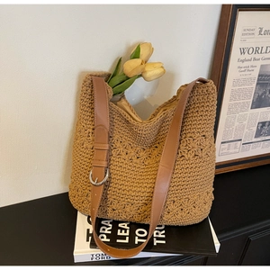 Close-up of woven tote bag with intricate knit patterns and brown leather strap