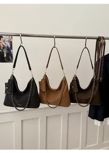 Detailed display of large tote bags in black, camel and brown with metal chain straps