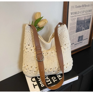 Detail of hollow floral woven texture and brown faux leather strap on beige tote