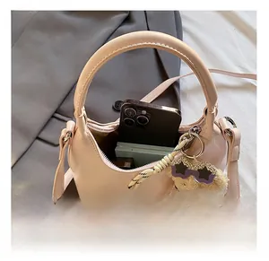 Macro shot of peach pink leather moon bag interior holding a phone and makeup kit