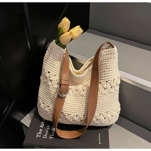 Close-up of hollow floral weave texture on cream crochet tote bag with brown leather strap