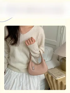 Close-up of a pink litchi grain hobo bag with a silver buckle and adjustable strap