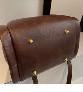 Detail view of the vintage brown leather bag bottom with four golden metal protective studs