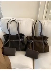 Detail of large brown suede tote bags with metal buckle and matching zipper pouches