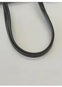 Detail of round leather handle with contrast white stitching on a black tote bag