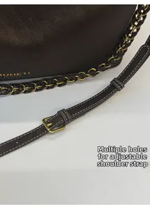 Detail of dark brown lychee leather tote with adjustable strap and metal pin buckle
