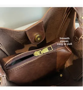 Close-up of dark brown leather tote interior with smooth zipper pouch and magnetic clasp