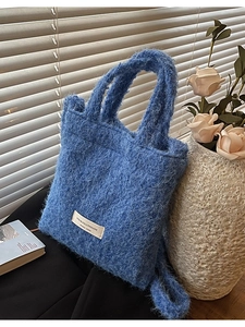 Blue plush wool tote bag with white woven label and spacious interior for daily use