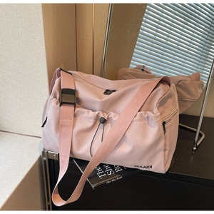 Detail of light pink travel bag showing waterproof nylon fabric and MULAIDI logo