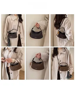 Detail view of stylish dumpling bag in brown and khaki with beaded charms