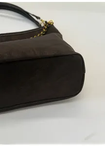 Detail shot of the widened base and litchi grain leather on the brown shoulder bag