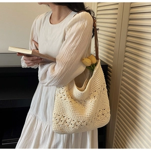 Detail of cream woven tote bag with 3D floral texture and brown leather shoulder strap