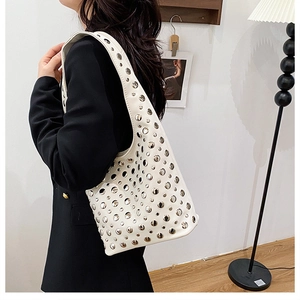 Gros plan du sac sous l'aisselle blanc avec clous argentés porté par un mannequin