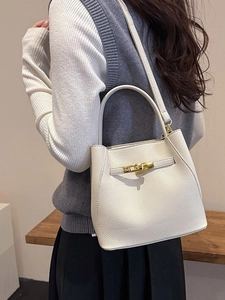 Elegant beige pebbled leather bucket bag with gold buckle for professional office style