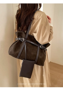 Detail view of large dark brown suede tote bag with belt buckle and brand strap