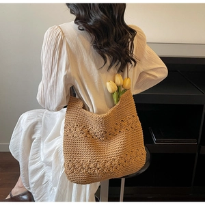 Detail of a brown hand-woven crochet tote bag featuring intricate floral petal patterns