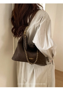Detailed view of deep brown suede tote with gold chain accent and leather strap