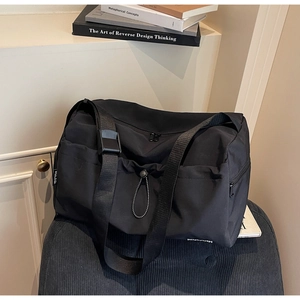 Detail view of large black travel bag with dry-wet separation and adjustable strap