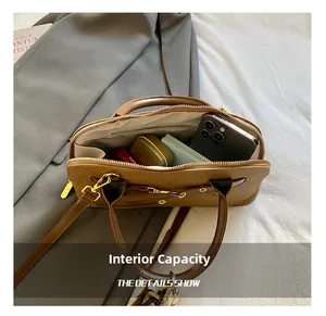 Vue du compartiment intérieur d'un sac Boston marron pour téléphone et cosmétiques