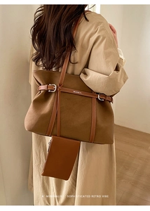 Detail view of large brown felt tote bag with leather straps on a model in minimalist room