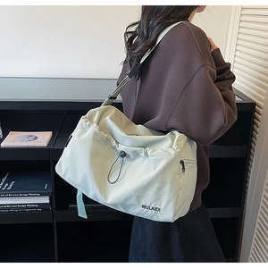 Side view of mint green travel bag with drawstring closure and side zipper pocket detail