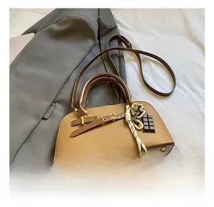 Détails du sac coquille vintage marron avec coutures en toile et boucles dorées