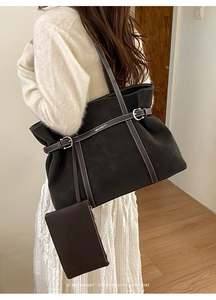 Detail of black suede tote bag set with white contrast stitching and a mini pouch