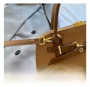Gros plan du sac à main marron texturé avec crochets en métal doré et double fermeture éclair