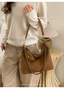 Brown leather tote with a thick gold chain strap and a matching mini triangle coin pouch