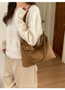 Detail of retro brown tote bag with metal chain strap and a matching small pouch