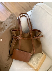 Detail of dark brown tote bag with matching pouch on a minimalist sofa scene
