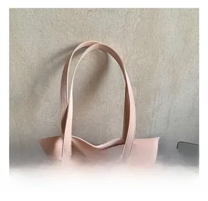 Close-up of comfortable reinforced handles on the light pink PU leather handbag