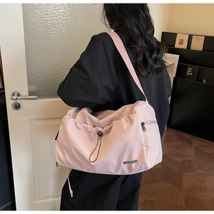 Detail view of pink waterproof travel bag with front drawstring and metal side zipper