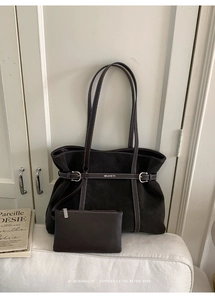 Detail view of coffee brown leather tote with contrast stitching and brand logo