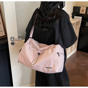 Close-up of pink travel bag with black drawstrings and side zipper pocket detail