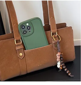 Close-up of brown leather shoulder bag featuring a functional front pocket and phone storage