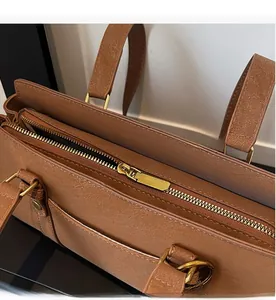 Close-up of smooth gold zipper and pebble texture on brown large shoulder bag