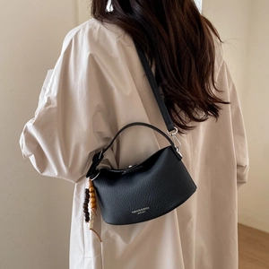 Detail of black lychee grain leather dumpling bag with decorative wooden beads
