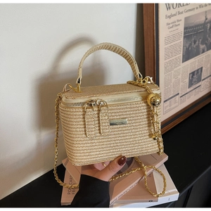 Detail of woven straw crossbody bag with gold chain strap and vintage styling