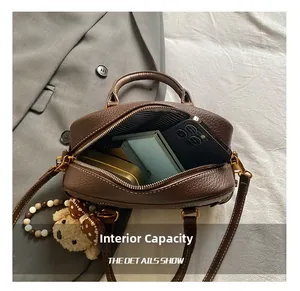 Internal capacity of brown pebble leather bag showing storage for phone and wallet