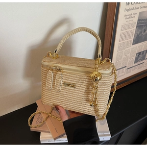 Detail of light beige woven box bag with dual zippers and gold chain strap