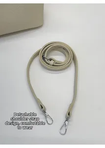 Détail de la bandoulière amovible en cuir grainé blanc cassé avec boucles argentées