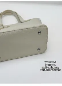 Détail de la base large du sac avec rivets anti-usure argentés et texture cuir grainé