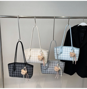 Detail of colorful plaid tote bags with plush bear charms and ribbon decorations