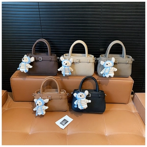 Detail of leather crossbody bags in five colors featuring cute teddy bear charms