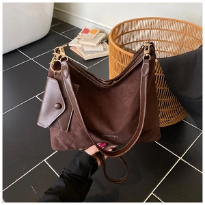 Detailed macro of dark brown suede tote bag featuring a matching hanging coin purse