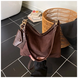 Close-up of brown suede tote bag with detachable mini purse and gold hardware detail