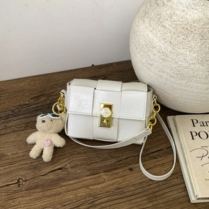 Détail du sac blanc à carreaux avec boucle cadran de montre et bandoulière chaîne dorée