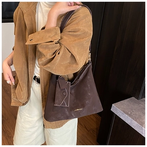 Close-up of a vintage dark brown suede tote bag with a small matching envelope pouch